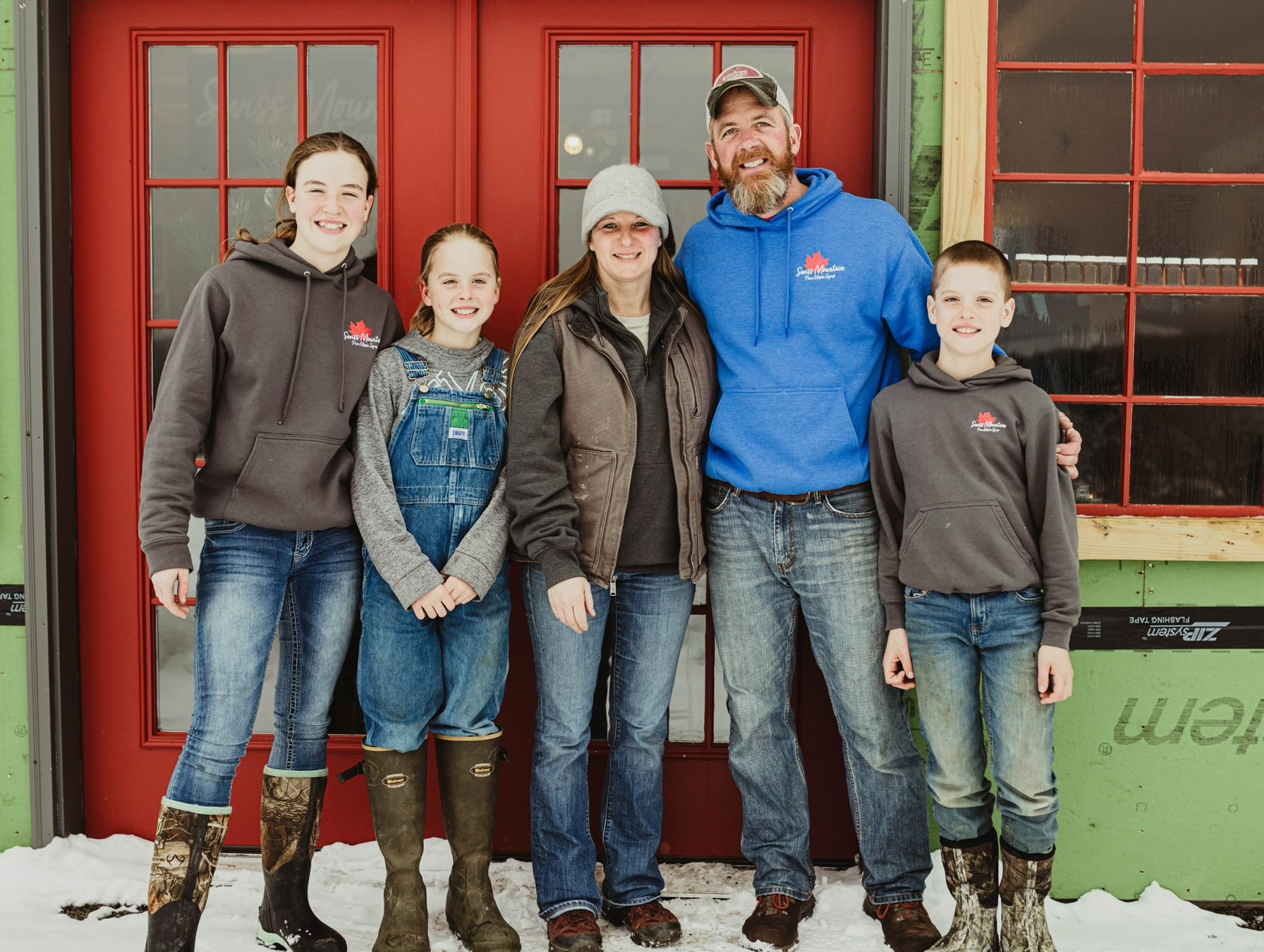 Russel Family standing in front of the srugarhouse